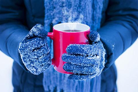 Person holding a mug in the snow