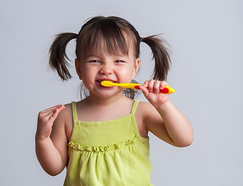 A child is brushing her teeth.